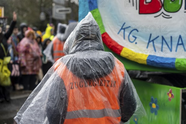 Rose Monday procession in Düsseldorf, parade participants, foot groups, make themselves rainproof, at street carnival, sometimes heavy rain, train ladder with rain cover, North Rhine-Westphalia, Germany