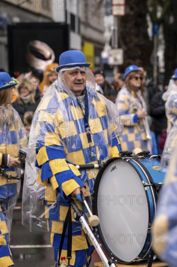 Rose Monday procession in Düsseldorf, parade participants, foot groups, make themselves rainproof, at street carnival, sometimes heavy rain, North Rhine-Westphalia, Germany