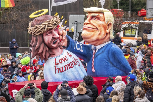 Rose Monday procession in Düsseldorf, theme car by wagon manufacturer Jacques Tilly, theme US President Donald Trump beats Jesus, ICE logo on his sleeve, against the domestic politics of the US government of North Rhine-Westphalia, Germany