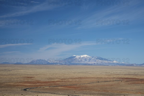 Winslow, Arizona - The San Francisco Peaks, seen from the Meteor Crater, about 45 miles distant. The highest, Humphreys Peak at 12, 637 feet, is the highest place in Arizona. The mountains have religious significance to Native American tribes in the area