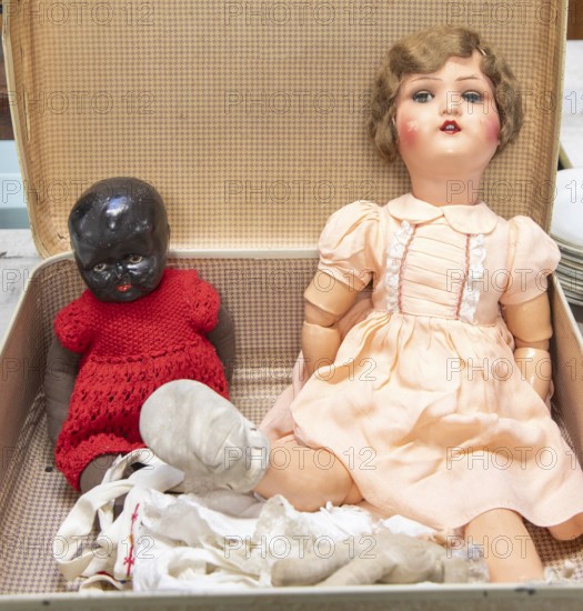 Dolls from 1920s to 1940sin a suitcase, one with articulated limbs and painted features, the other is a Black Baby Doll