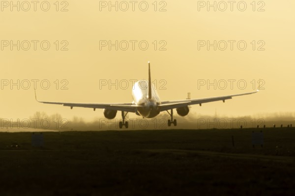 Boeing 777 commercial passenger airliner jet aircraft landing on a runway at sunset at London Stansted airport, Essex, England, United Kingdom