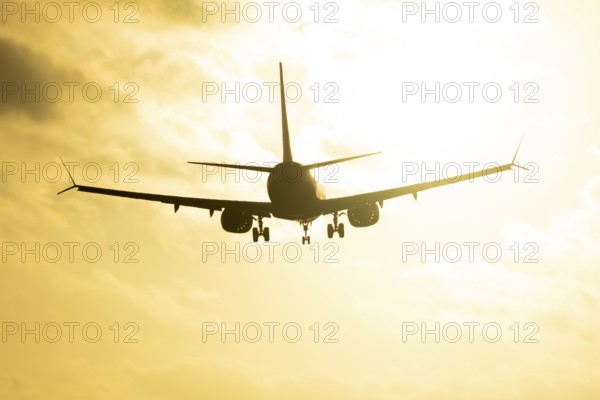 Boeing 737 commercial passenger airliner jet aircraft in flight on approach to land over runway lights at sunset at London Stansted airport, Essex, England, United Kingdom