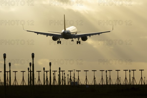 Airbus A321 commercial passenger airliner jet aircraft of Pegasus airlines flying on approach to land over runway lights at sunset at London Stansted airport, Essex, England, United Kingdom