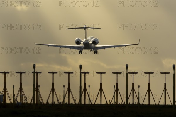 Executive business jet aircraft in flight on approach to land at sunset at London Stansted airport, Essex, England, United Kingdom