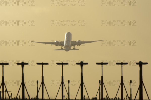 Commercial passenger airliner jet aircraft taking off in flight at sunset at London Stansted airport, Essex, England, United Kingdom