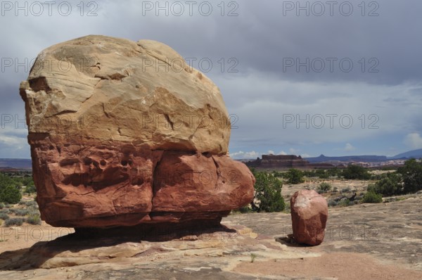 Large round boulder in an open desert landscape under a cloudy sky, Canyonlands National Park, Utah, USA