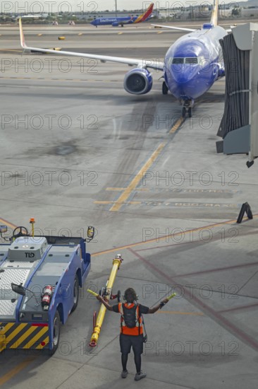 Phoenix, Arizona - A ground crew worker directs a Southwest Airlines jet as it arrives at Sky Harbor International Airport