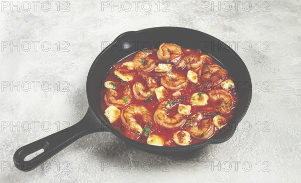 Greek saganaki, in an iron pan, saganaki with shrimp, shrimp in tomato sauce, with pepper and feta cheese, homemade, no people