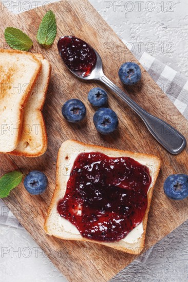 Toast with blueberry jam, on a wooden chopping board, breakfast, homemade, no people