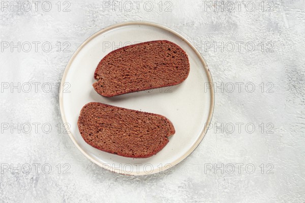 Delicious slices of homemade dark bread on a simple ceramic plate in a kitchen setting