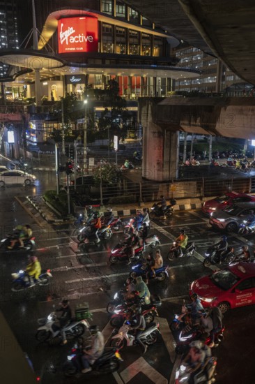 Bangkok, Thailand. March 26th 2025. A busy traffic interchange with lots of motorcycles during wet evening rush hour in Sathon Square, Bangkok, Thailand, Asia