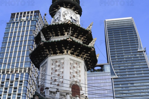 Bangkok, Thailand. March 4th 2025. The Chinese Clock Tower seen with the modern high rise buildings of Bangkok in Lumphini Park, Thailand