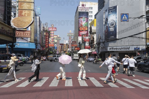 Bangkok, Thailand. March 25th 2025. Tourists crossing Yaowarat Road, the heart of Chinatown and popular destination for street food and entertainment in Bangkok, Thailand