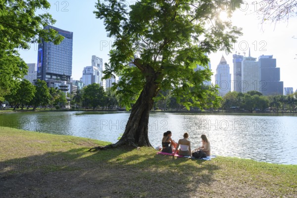 Bangkok, Thailand. March 4th 2025. People enjoy a picnic in the calm and peaceful environment beside the lake in Lumphini Park, Bangkok