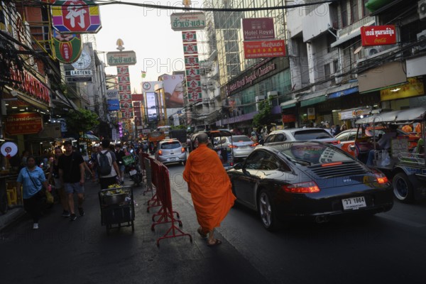 Bangkok, Thailand. February 18th 2025. A Buddhist monk walks along Yaowarat Road, busy with Tuck-Tucks and traffic in the heart of Chinatown, Bangkok, Thailand