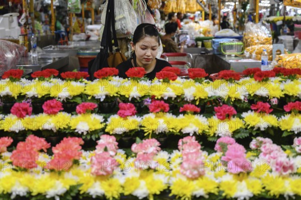 Bangkok, Thailand. March 2rd 2025. A Thai woman at a stall selling traditional flower arrangements at Pak Khlong Talat-Bangkok Flower Market