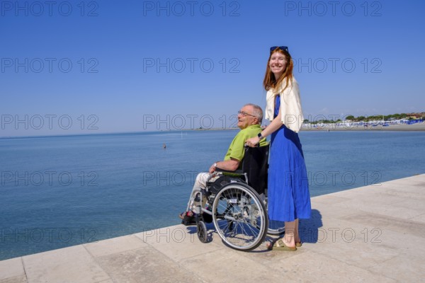 Senior in wheelchair looking at the sea, vacation with a handicap, Grado, Julian-Friuli, Adriatic Sea, Italy