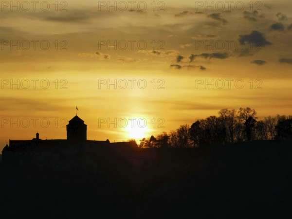 Silhouette of Rosenberg Fortress in Kronach in front of dramatic sunset sky, Frankenwald nature park Park