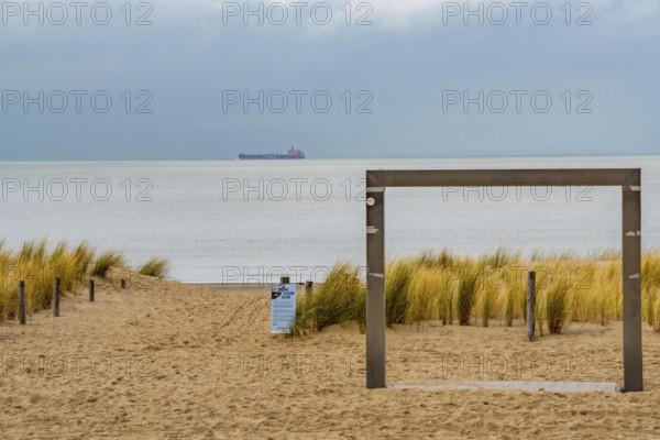 Winter break, on Zeedijk-Knokke, beach promenade in Knokke-Heist, on the North Sea beach, dreary winter day, beach shower, freighter on the North Sea, Belgium