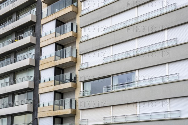 Facades of residential buildings on Zeedijk-Knokke, beach promenade in Knokke-Heist, largely uninhabited in winter, on the North Sea beach, dreary winter day, mostly apartment buildings with rental or condominiums, high-rise buildings on the street, Belgium