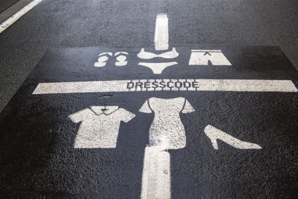 Winter break, on the Zeedijk-Knokke, beach promenade in Knokke-Heist, commandment sign, prohibition sign, for the dress code on the North Sea beach and in the city, painted on the road surface, dreary winter day, Belgium