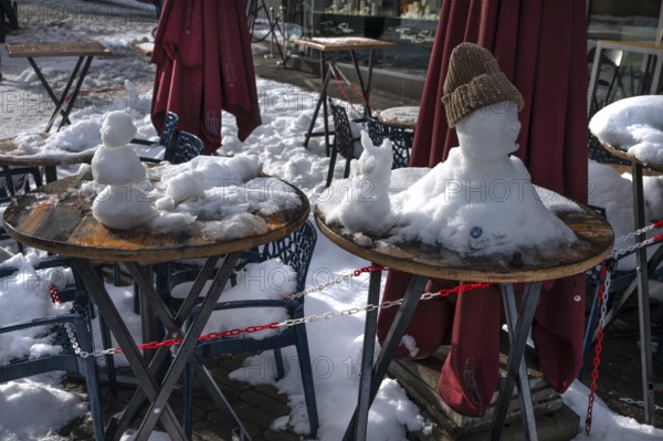 Little snowmen on bistro tables in front of a café, Nuremberg, Middle Franconia, Bavaria, Germany