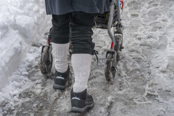 Detail, elderly man pushes his walker through slush in the city, Nuremberg, Middle Franconia, Bavaria Germany