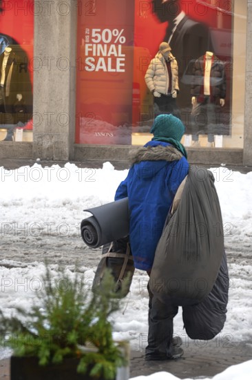 Homeless person wearing his sleeping utensils in winter, Bavaria, Germany