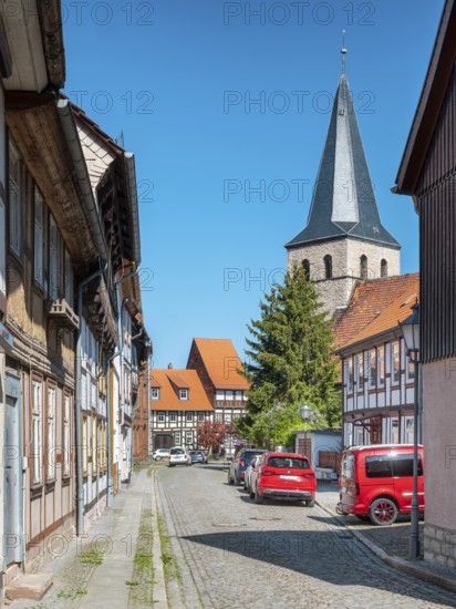 Street with half-timbered houses and cobblestones, in the back the church of St. Nikolai, half-timbered town of Osterwieck, Harz, Harzvorland, Saxony-Anhalt, Germany