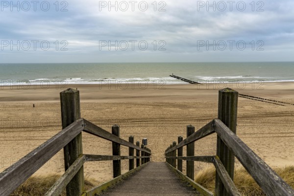 Coastal protection, through wooden posts, paalhoofden, on the beach, breakwater, the piles, some of which are rammed into the sandy soil in double rows, slow down the waves and ocean currents and thus slow down the flow rate of seawater, so less sand is washed away from the stand, near Domburg, Walcheren peninsula in the Dutch province of Zeeland