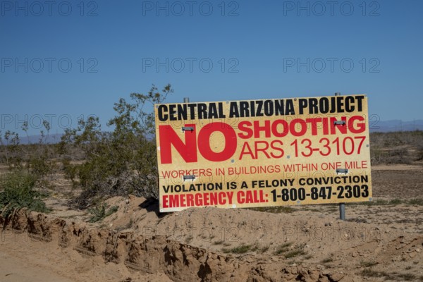 Buckeye, Arizona - A sign near the Central Arizona Project canal prohibits shooting because of workers in nearby buildings