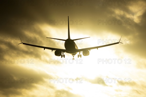 Boeing 737 commercial passenger airliner jet aircraft of Ryanair airways in flight on approach to land over runway lights at sunset at London Stansted airport, Essex, England, United Kingdom