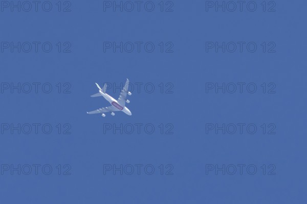 Airbus A380 commercial passenger airliner jet aircraft of Emirates airlines flying in a blue sky, England, United Kingdom