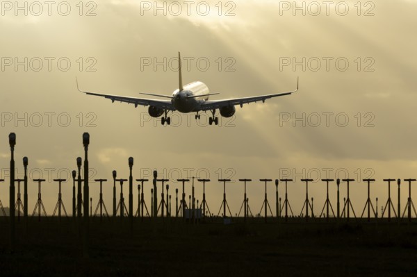 Airbus A321 commercial passenger airliner jet aircraft of Pegasus airlines flying on approach to land over runway lights at sunset at London Stansted airport, Essex, England, United Kingdom