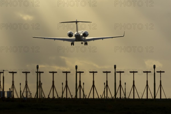 Executive business jet aircraft in flight on approach to land at sunset at London Stansted airport, Essex, England, United Kingdom
