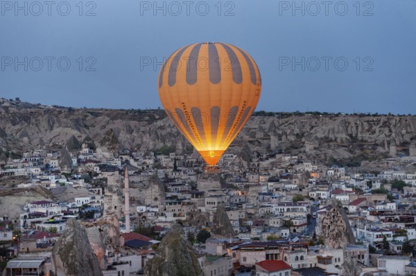 Goreme, Cappadocia. Turkey. October 14th 2018. A hot air balloon flies over the Anatolian village of Goreme in Cappadocia, known for fairy chimneys and cone shaped rocks