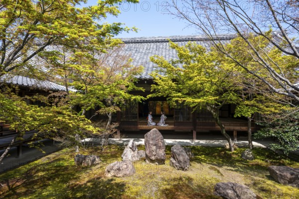 Two Japanese woman dressed in kimono sitting at an open door, courtyard of O-shoin with Shione Garden with Shione Garden, Kennin-ji Temple, Higashiyama, Kyoto, Japan