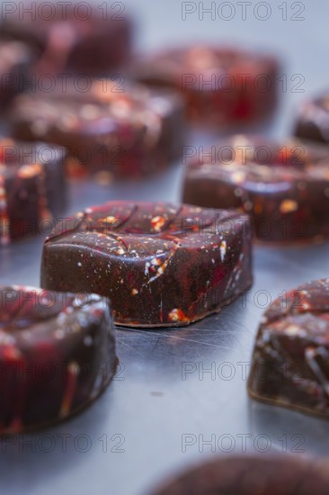 Close-up of a reddish shimmering chocolate with a smooth surface, vegan chocolates production, Haselstaller Hof, Gechingen, Germany