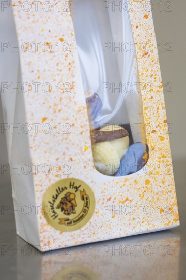 White gift box with colorful splashes and visible logo, Easter production of regional products, Haselstaller Hof, Gechingen, Calw district, Germany