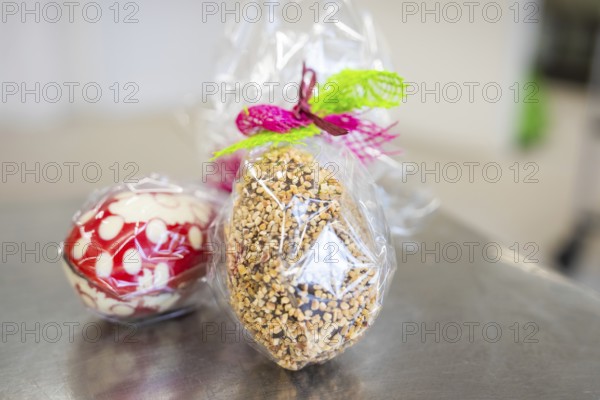 Gift wrapping of Easter eggs made from sweets and nuts in transparent foil, Easter production of regional products, Haselstaller Hof, Gechingen, Calw district, Germany