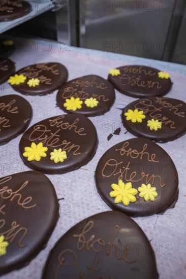 Chocolate Easter eggs decorated with yellow flowers, served on a tray, Easter production of regional products, Haselstaller Hof, Gechingen, Calw district, Germany