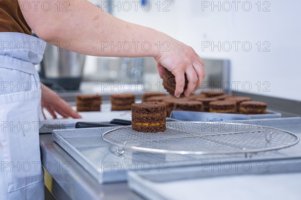 Person places cookies on a grid in the kitchen, vegan cake production, Haselstaller Hof, Gechingen, Germany