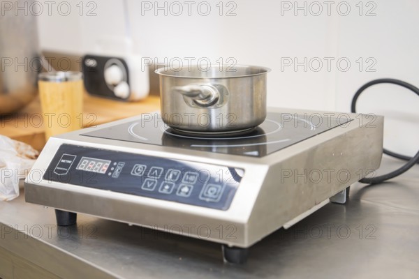 Stainless steel pot on an inductive hotplate in a modern kitchen environment, vegan cake production, Haselstaller Hof, Gechingen, Germany