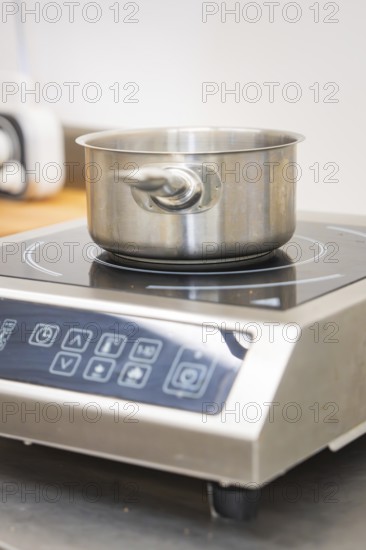 Stainless steel pot on an inductive hotplate in the kitchen, vegan cake production, Haselstaller Hof, Gechingen, Germany