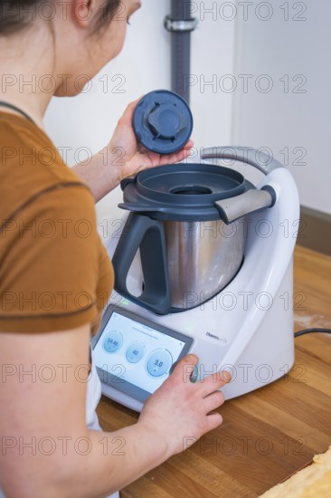 Person places the lid on a food processor during preparation, vegan cake production, Haselstaller Hof, Gechingen, Germany