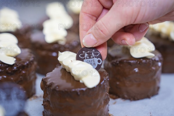 A small chocolate dessert is decorated with a café logo, Vegan Törtchen Produktion, Haselstaller Hof, Gechingen, Germany