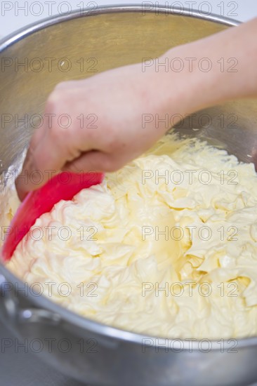 Hand stir buttercream in a metal bowl with a pink dough spatula, vegan cake production, Haselstaller Hof, Gechingen, Germany