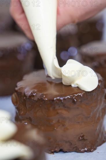 Hand decorated a chocolate cake with cream from a piping bag, vegan cake production, Haselstaller Hof, Gechingen, Germany