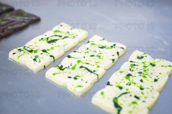 White chocolate bars with green patterns lying side by side on a table, vegan chocolate production, Haselstaller Hof, Gechingen, Germany